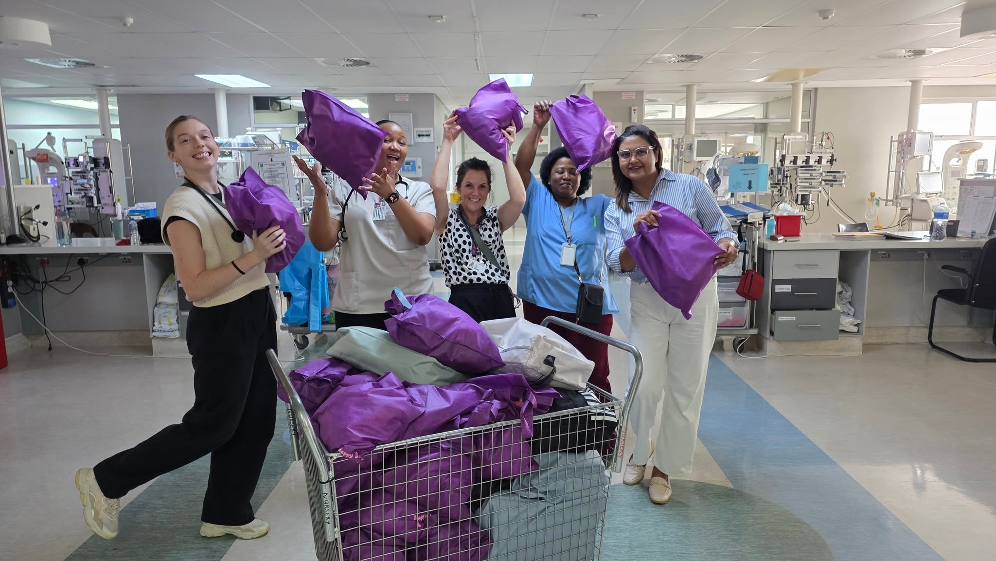 Mothers holding their newborn babies and Nappy Bag Initiative bags at a Durban hospital