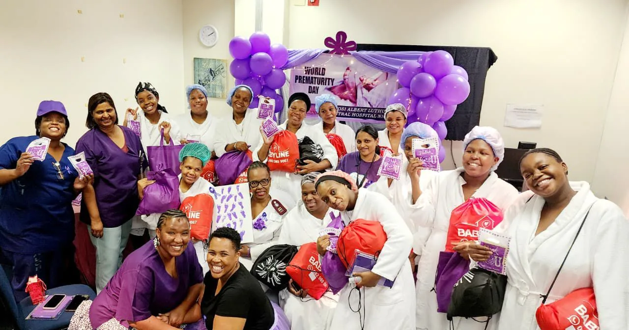 Nurses and volunteers holding donated items during a Nappy Bag Initiative outreach event